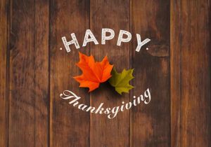 Rustic Wood Background Reading Happy Thanksgiving Sign with Fall Leaves
